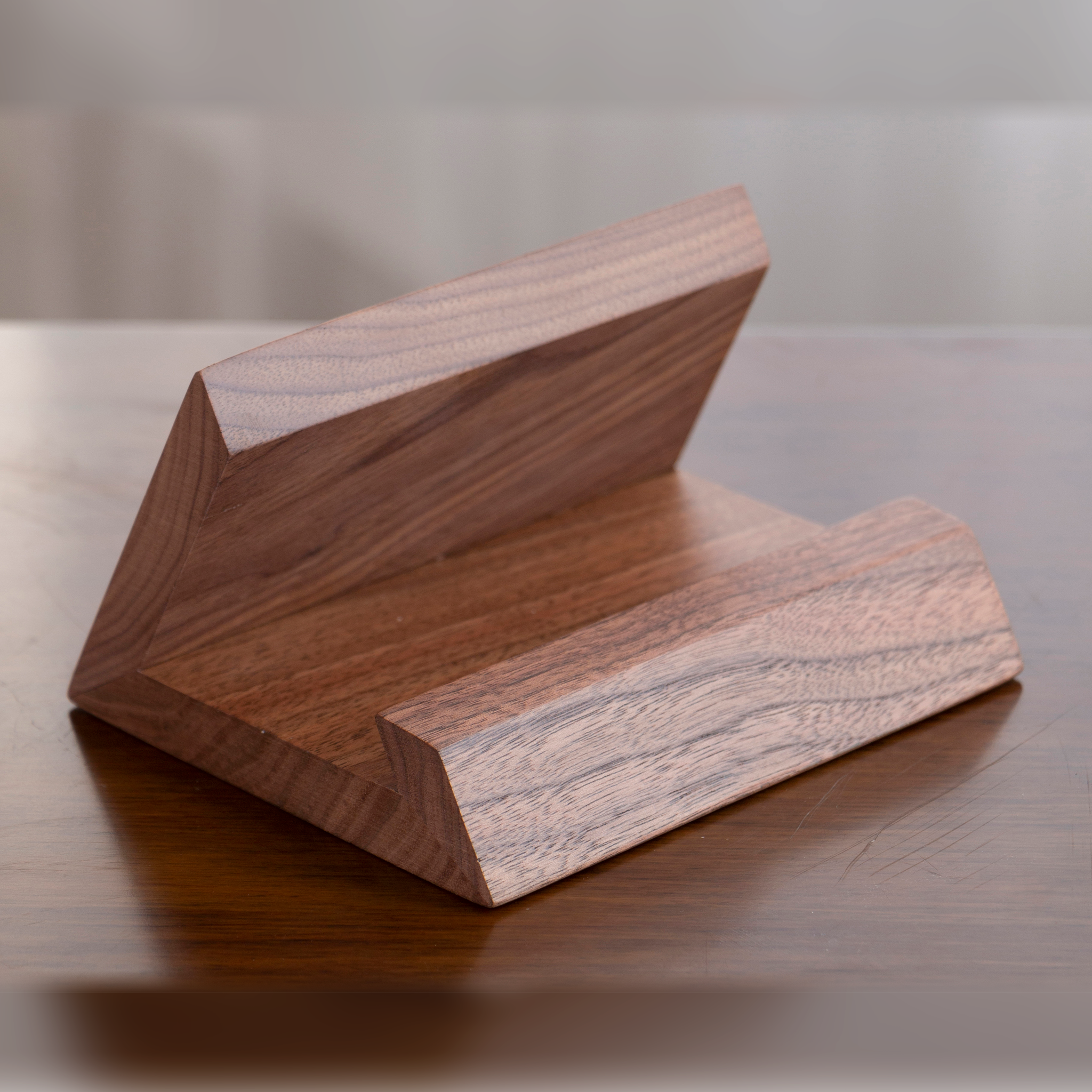 Support de bureau en bois massif noyer pour téléphone sur fond sombre